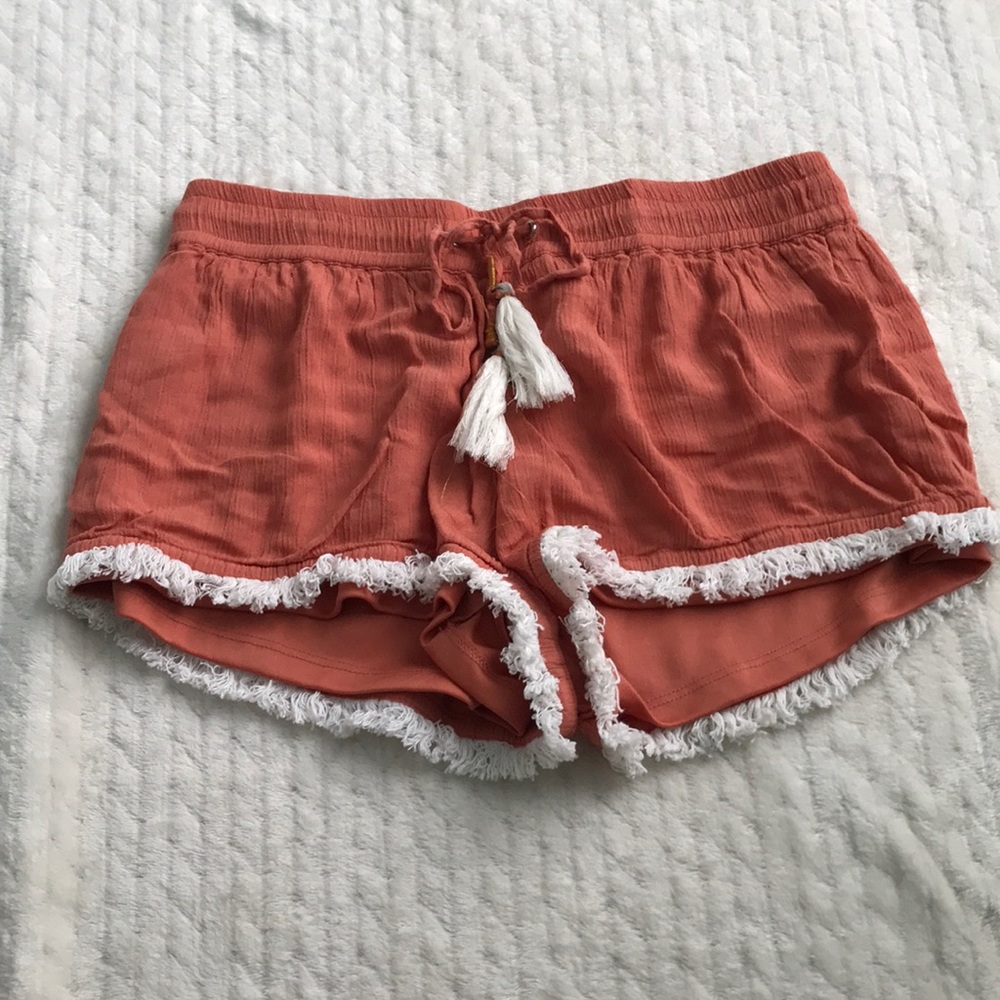 Orange shorts with white tassels and fringe